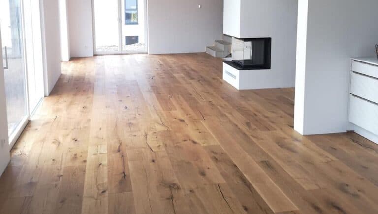 Ein Innenraum mit Holzboden, einem weißen Kamin und Glasschiebetüren.