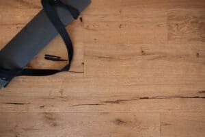 Eine aufgerollte Yogamatte, die auf einem Holzboden liegt.