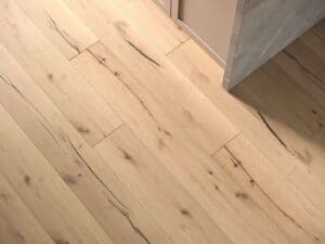Ein heller Dielenboden mit dunkler Maserung neben einem Eckschrank.