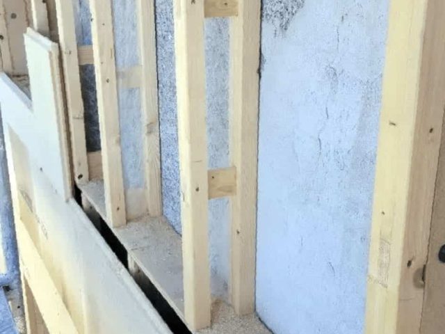 Die Holzständerwände sind mit einigen Dämmplatten dazwischen dargestellt, während andere Abschnitte offen gelassen werden, so dass die Wandstruktur sichtbar ist.