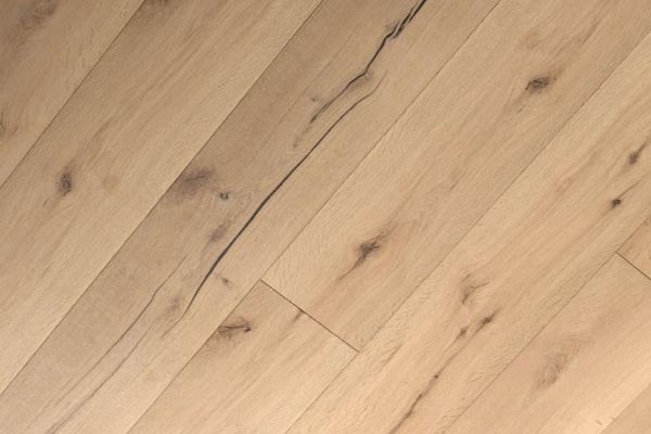 Nahaufnahme von hellbraunen Holzdielen mit natürlichen Maserungen, Ästen und einer sichtbaren dunklen Linie, die sich durch eine der Dielen zieht.